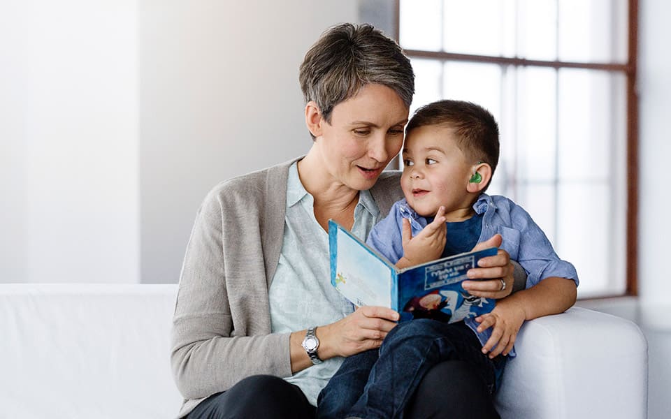 reading a book to a child with a hearing aid